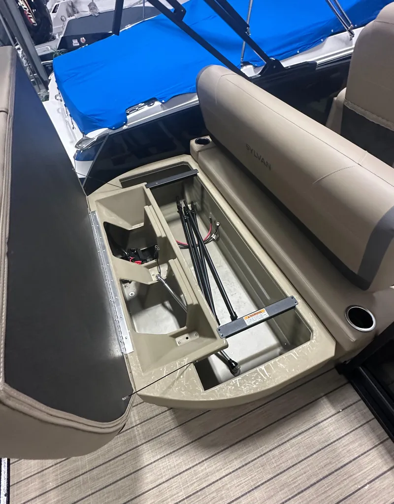 Slide: The Image of 2025 Sylvan MIRAGE X1 CLZ DH boat interior storage compartment with open seat and beige upholstery. - 8