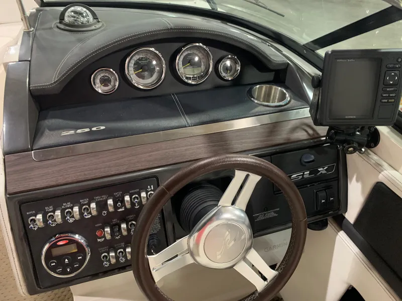 Slide: The Image of 2014 Sea Ray SLX 250 dashboard with steering wheel, gauges, and control panel. - 10