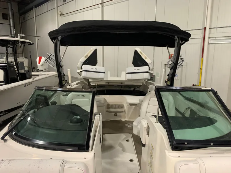 Slide: The Image of 2014 Sea Ray SLX 250 boat with black canopy in indoor storage. - 12