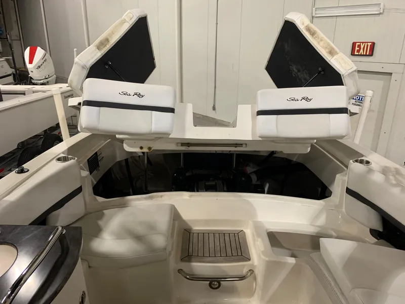 Slide: The Image of 2014 Sea Ray SLX 250 boat interior with white seating and open engine compartment. - 7