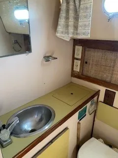Slide: The Image of 1970 Pearson 35 Sloop bathroom with sink, mirror, and storage compartments. - 18