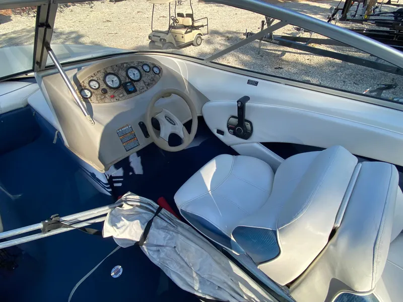 Slide: The Image of 2001 Bayliner 215 Bowrider boat interior with steering wheel and seating. - 11