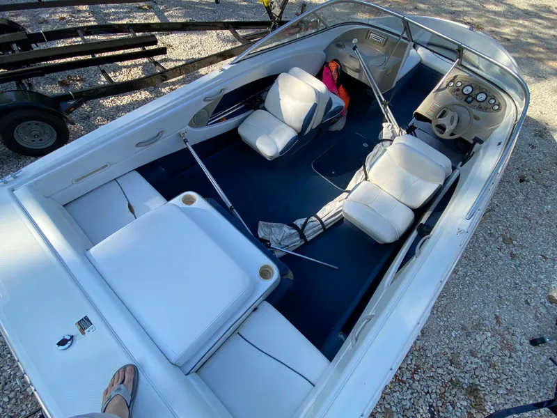 Slide: The Image of 2001 Bayliner 215 Bowrider boat interior with white seating and blue flooring. - 16