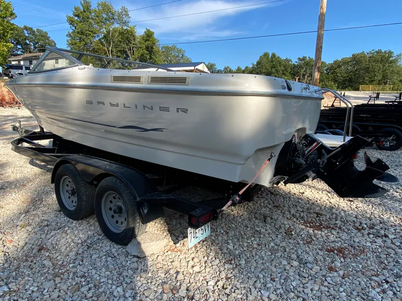 Slide: The Image of 2001 Bayliner 215 Bowrider on a trailer in a gravel lot. - 22