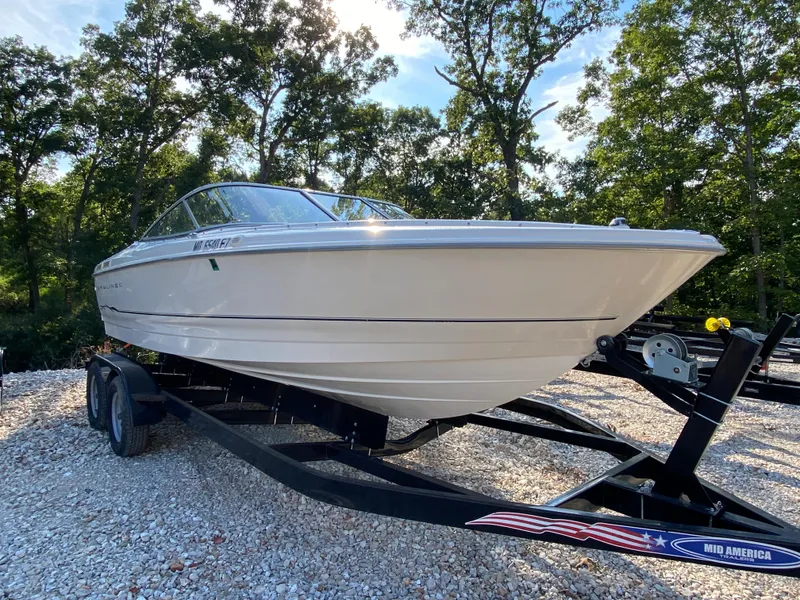 Slide: The Image of 2001 Bayliner 215 Bowrider on a trailer in a wooded area. - 24