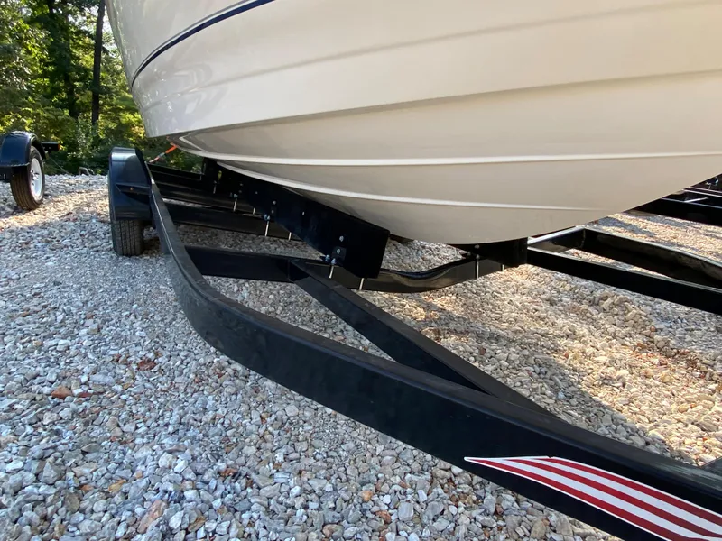 Slide: The Image of 2001 Bayliner 215 Bowrider on a black boat trailer, parked on gravel. - 27