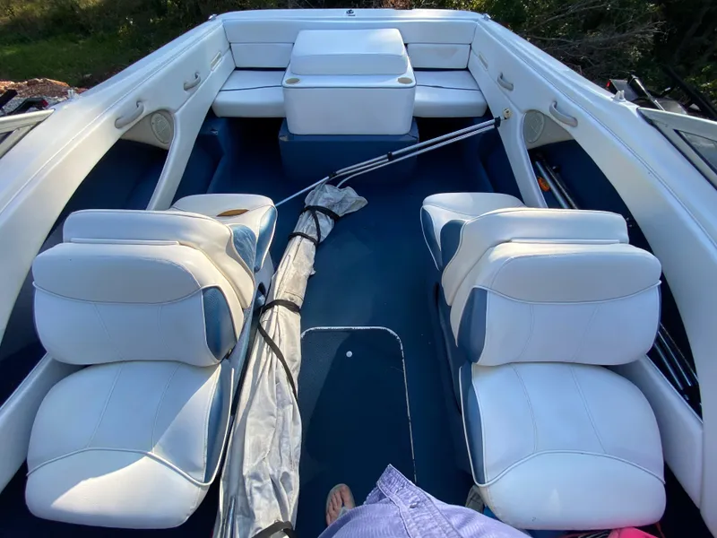 Slide: The Image of 2001 Bayliner 215 Bowrider interior with white seating and blue accents. - 4
