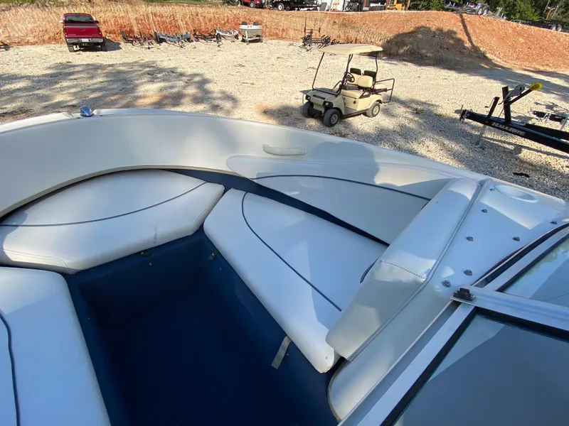 Slide: The Image of 2001 Bayliner 215 Bowrider boat interior with white seating and blue flooring. - 6