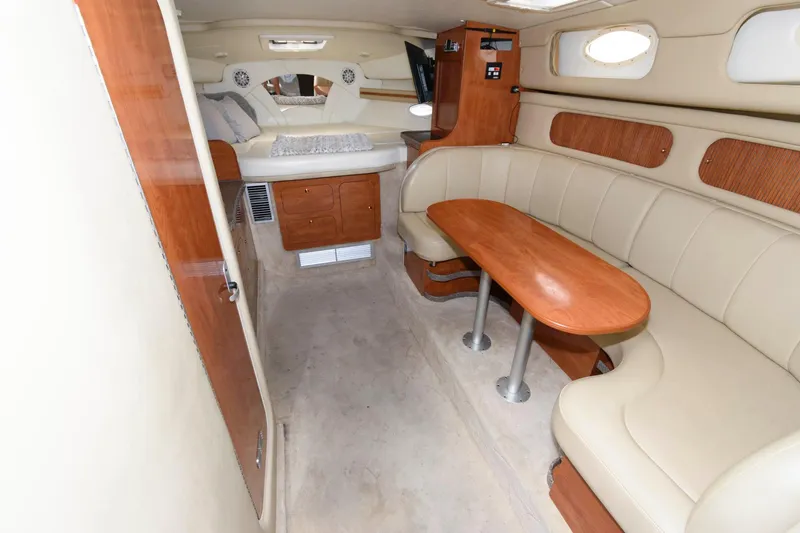 Slide: The Image of Interior of 2005 Rinker Fiesta Vee 342 with beige seating and wooden table. - 15