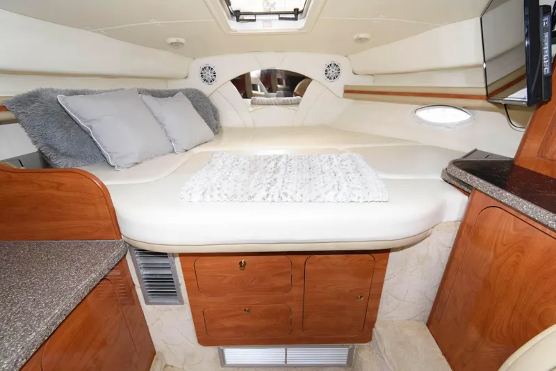 Slide: The Image of 2005 Rinker Fiesta Vee 342 cabin interior with bed and wooden cabinetry. - 16