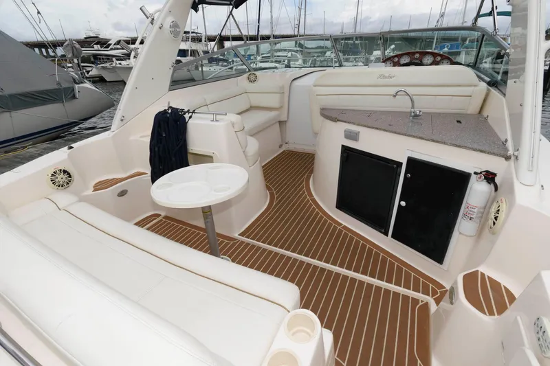 Slide: The Image of 2005 Rinker Fiesta Vee 342 boat interior with seating, table, and kitchenette. - 4