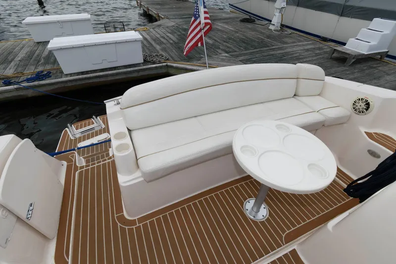 Slide: The Image of 2005 Rinker Fiesta Vee 342 boat interior with white seating and table at dock. - 5
