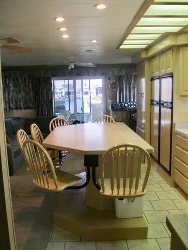 Slide: The Image of Spacious kitchen with wooden dining table, chairs, and modern appliances in a Horizon "one week a month" model. - 11