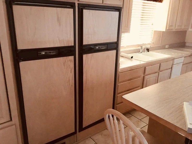 Slide: The Image of Kitchen with dual wooden-paneled refrigerators, beige cabinets, and a sunlit countertop. Horizon model, 2000. - 2