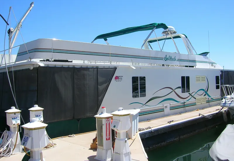 Slide: The Image of Houseboat docked at marina, Horizon model "One Week a Month," year 2000, with colorful wave design. - 4