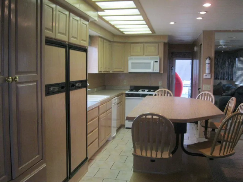 Slide: The Image of Spacious kitchen in Horizon RV, 2000 model, featuring wooden cabinets and dining area. - 5