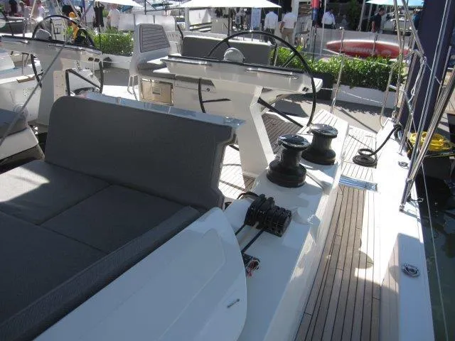 Slide: The Image of 2025 Jeanneau Yacht 65 deck with steering wheel and seating area. - 34