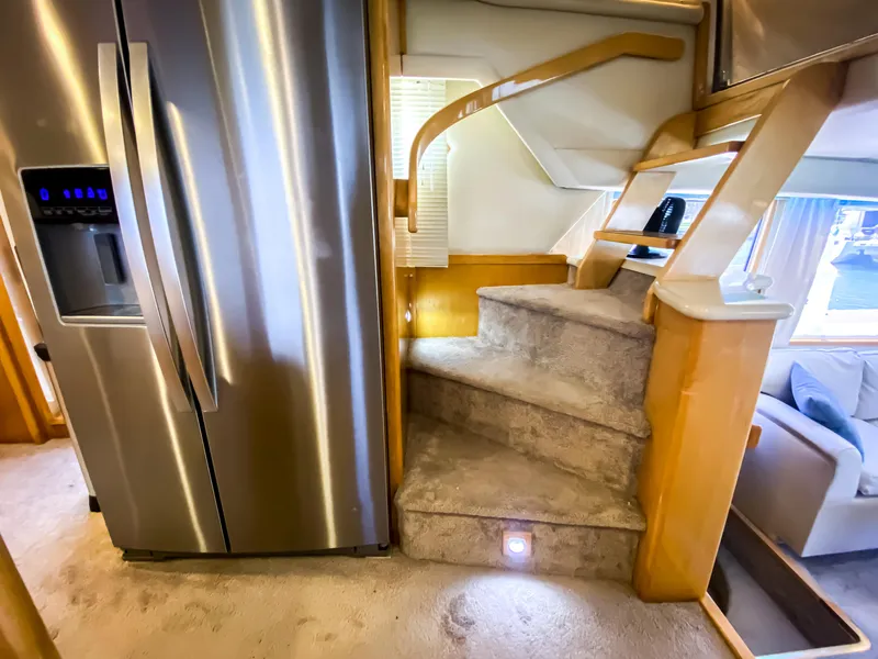 Slide: The Image of Interior of a 1999 Navigator 5800 yacht with stainless steel fridge and carpeted stairs. - 14