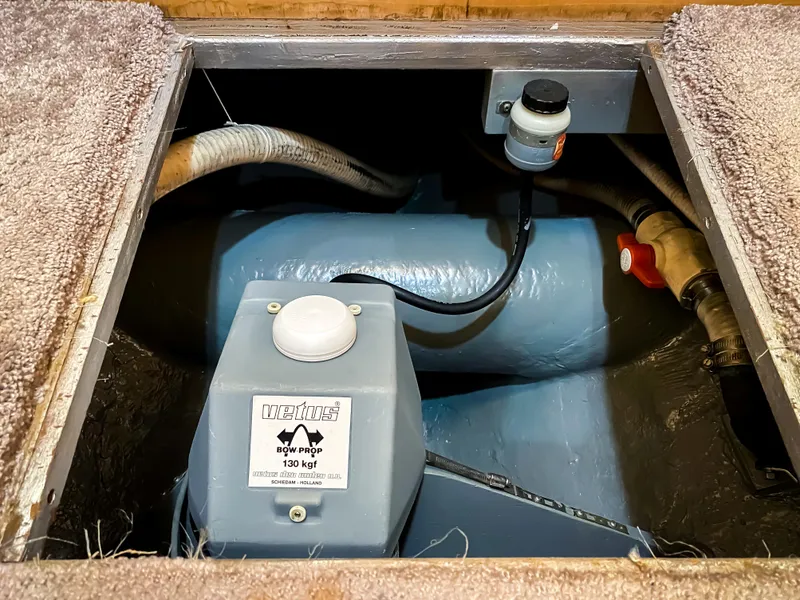 Slide: The Image of Engine compartment of a 1999 Navigator 5800 boat, featuring mechanical components and hoses. - 24