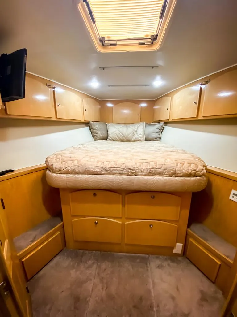 Slide: The Image of 1999 Navigator 5800 interior with cozy bed, wooden cabinets, and overhead skylight. - 27
