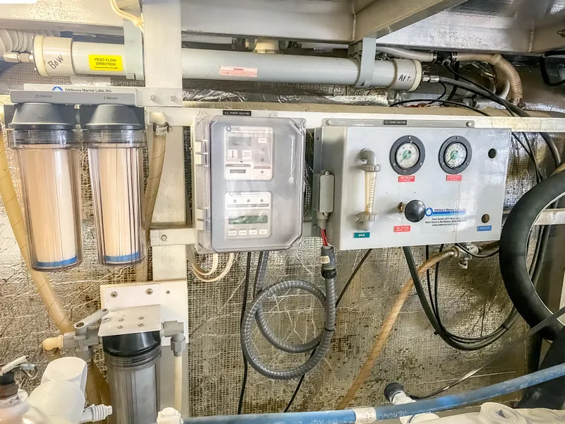 Slide: The Image of Control panel and filtration system in a 1999 Navigator 5800 yacht engine room. - 48