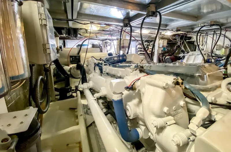 Slide: The Image of Engine room of a 1999 Navigator 5800 yacht, showcasing complex machinery and wiring. - 49