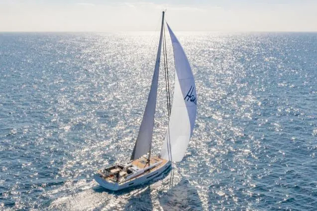 Slide: The Image of Sailing yacht Hanse 460 (2025) gliding on sparkling ocean waters under clear skies. - 2
