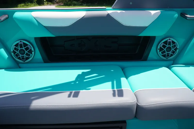 Slide: The Image of 2022 Axis A22 boat interior with teal and gray seating, featuring built-in speakers. - 13