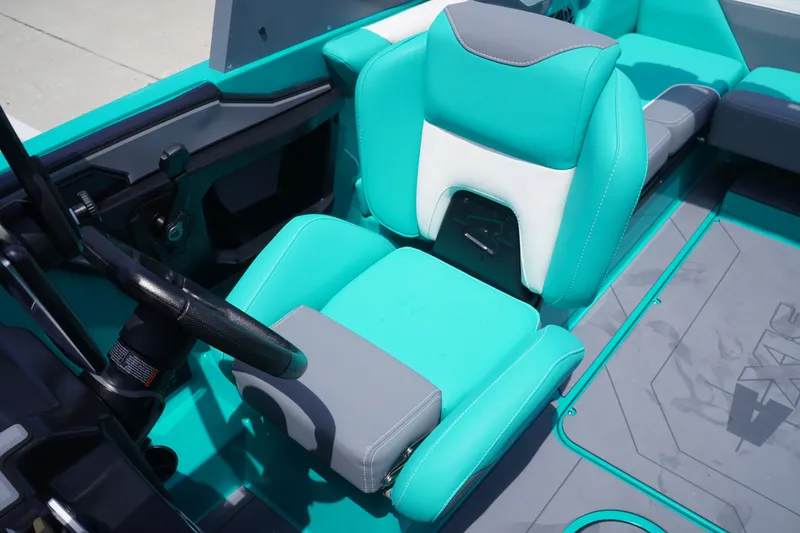 Slide: The Image of 2022 Axis A22 boat interior with teal and white seating, steering wheel, and modern design. - 16