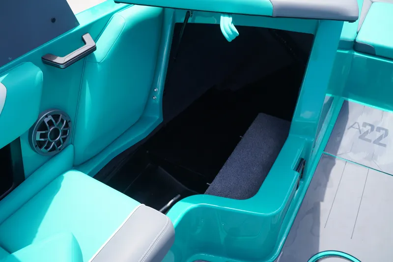 Slide: The Image of 2022 Axis A22 boat interior with teal seating and storage compartment. - 22
