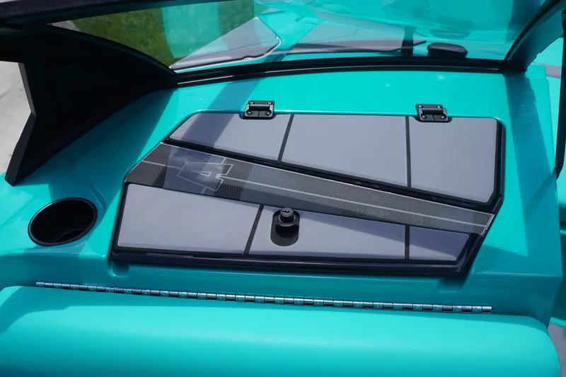 Slide: The Image of 2022 Axis A22 boat dashboard with teal accents and cup holder. - 24