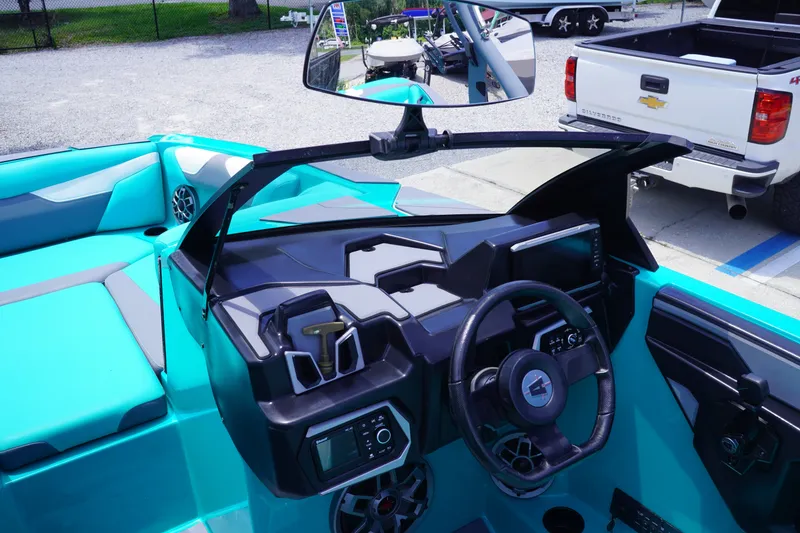 Slide: The Image of 2022 Axis A22 boat dashboard with steering wheel, controls, and vibrant turquoise seating. - 17