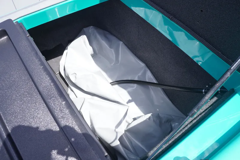 Slide: The Image of 2022 Axis A22 boat storage compartment with a white cover and hose inside. - 34