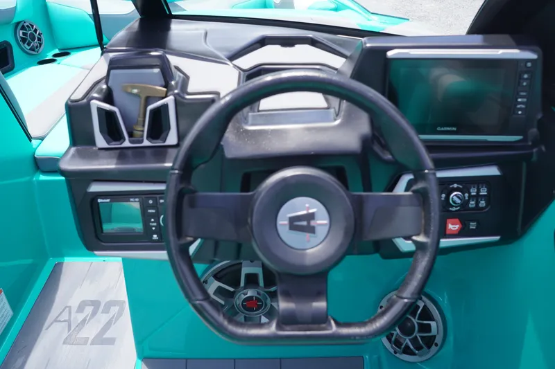 Slide: The Image of 2022 Axis A22 boat dashboard with steering wheel, digital displays, and teal interior. - 18