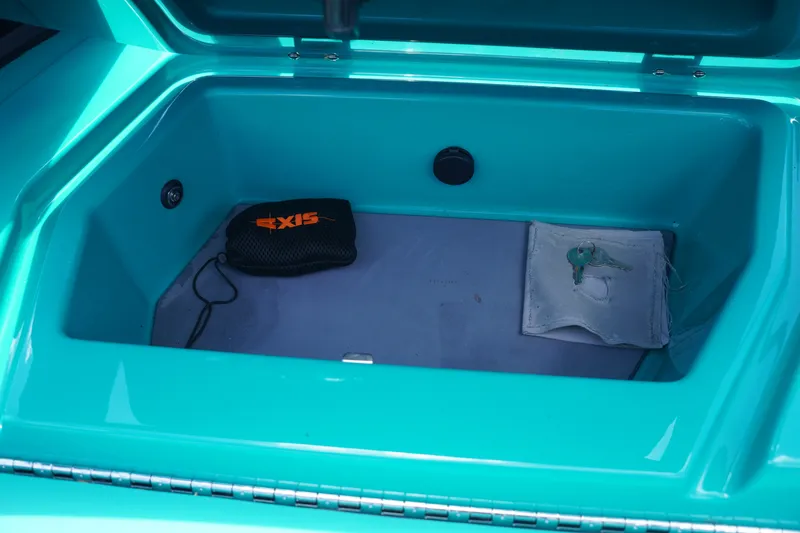 Slide: The Image of Open storage compartment in 2022 Axis A22 boat with keys and branded pouch. - 25