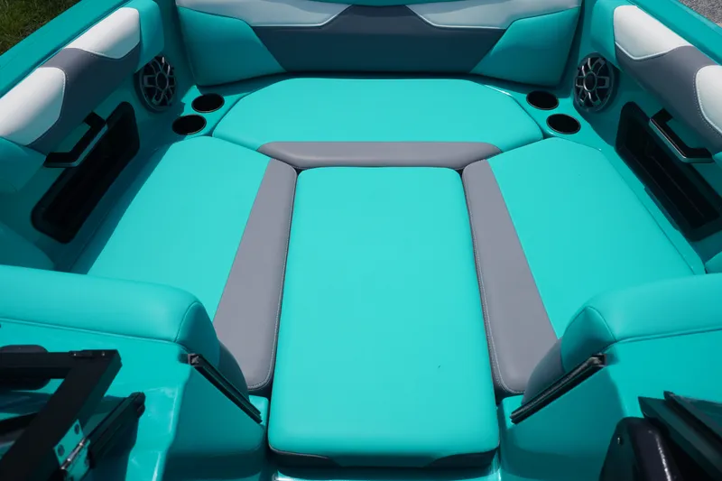 Slide: The Image of Interior of 2022 Axis A22 boat with teal and gray seating, cup holders, and speakers. - 26