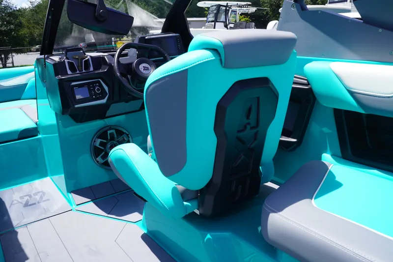 Slide: The Image of 2022 Axis A22 boat interior with turquoise seating and modern dashboard design. - 15