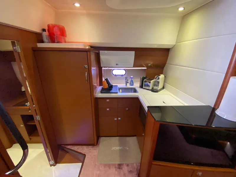 Slide: The Image of 2013 Prestige 440 S yacht kitchen with modern appliances and wood cabinetry. - 16