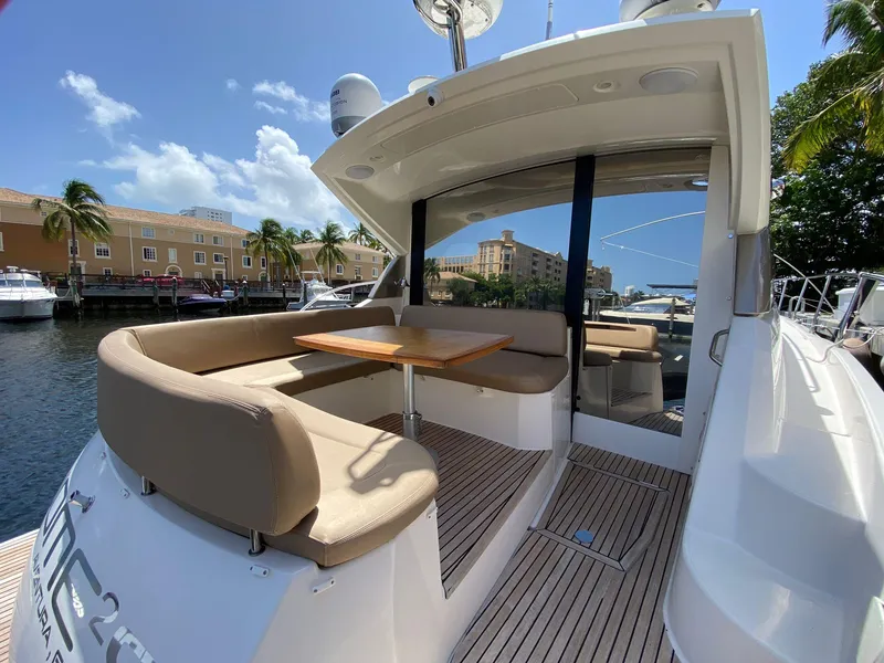 Slide: The Image of 2013 Prestige 440 S yacht with outdoor seating and table, docked near waterfront buildings. - 25