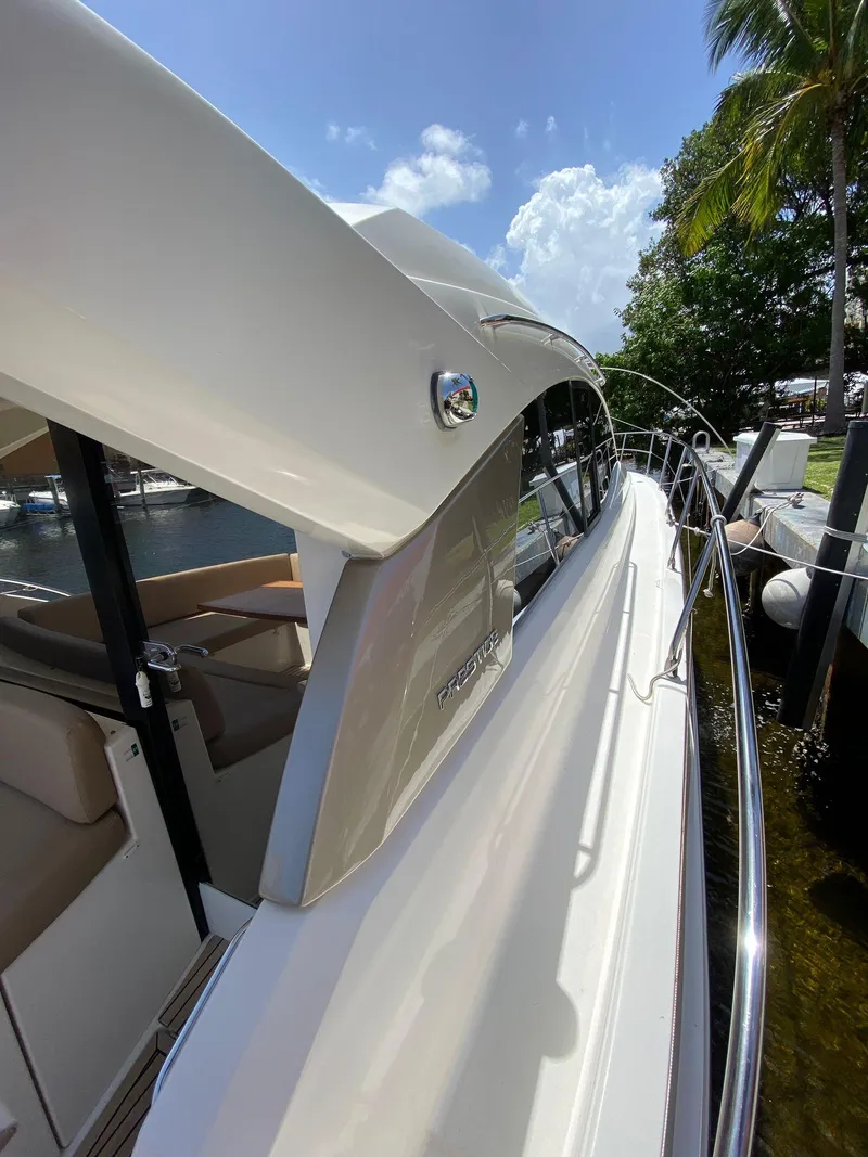 Slide: The Image of 2013 Prestige 440 S yacht docked under a sunny sky with palm trees. - 30