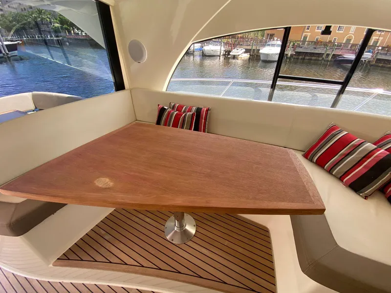 Slide: The Image of Luxurious interior of 2013 Prestige 440 S yacht with wooden table and striped cushions. - 9