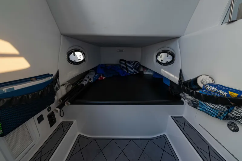 Slide: The Image of 2024 Nor-Tech 390 Center Console cabin interior with storage compartments and portholes. - 25
