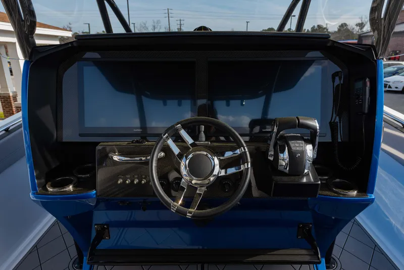 Slide: The Image of 2024 Nor-Tech 390 Center Console boat helm with modern controls and steering wheel. - 6