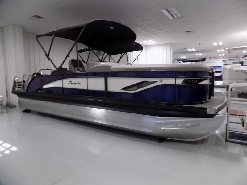 Slide: The Image of 2024 Barletta Corsa 23U pontoon boat in showroom, featuring sleek design and spacious interior. - 0