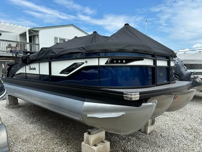 Slide: The Image of 2024 Barletta Corsa 23U pontoon boat with cover, parked on blocks. - 3