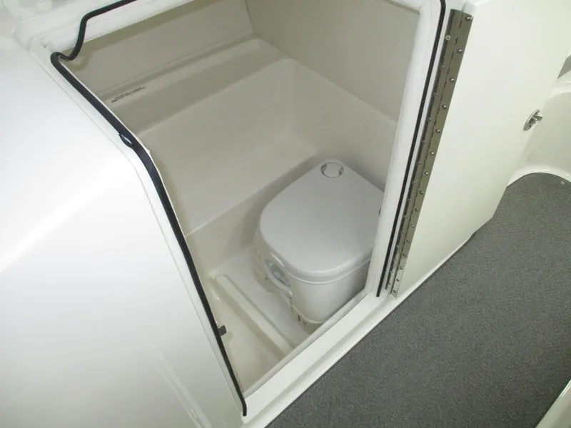 Slide: The Image of The image shows a compact toilet in a boat, surrounded by white walls. - 14