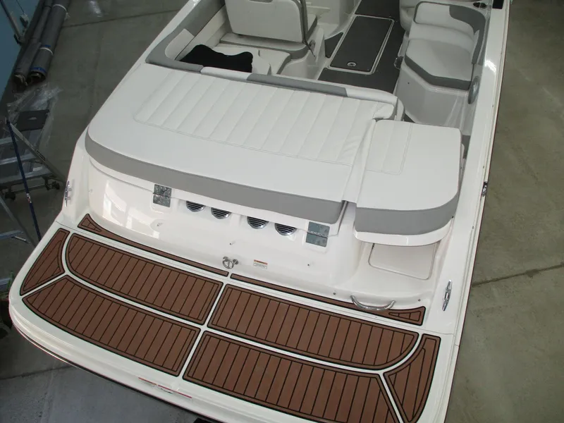 Slide: The Image of The image shows the rear of a 2016 Bayliner VR6 Bowrider I/O with a spacious sun pad and teak-style flooring. - 2