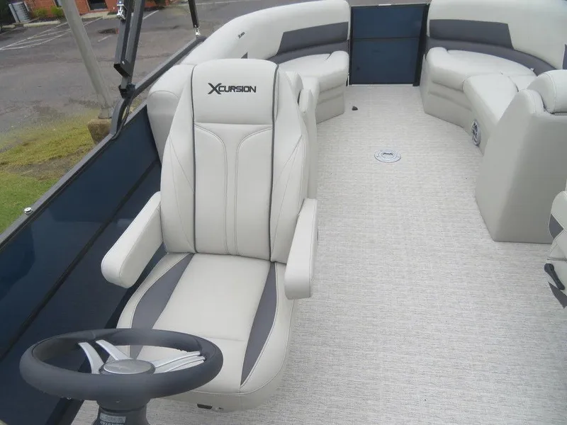 Slide: The Image of 2022 Xcursion 243RFX boat interior with captain's chair and seating. - 16