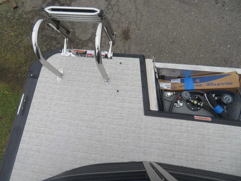 Slide: The Image of 2022 Xcursion 243RFX boat deck with ladder and storage compartment. - 25