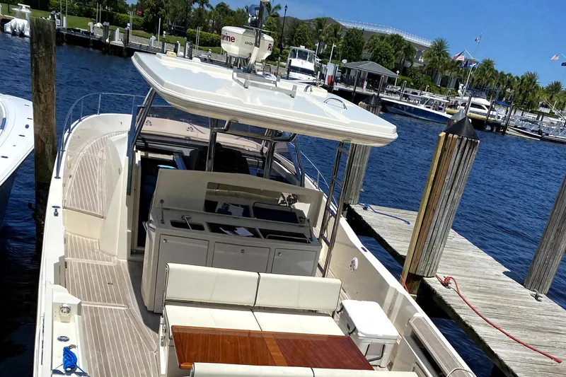 Slide: The Image of Azimut Atlantis Verve Outboard 2014 docked at marina, featuring spacious deck and seating area. - 1